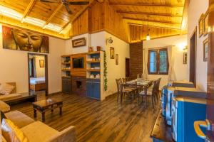 a living room with a table and a dining room at SaffronStays Gardens On The Lake, Bhimtal - pet-friendly garden villa by the lake in Bhīm Tāl