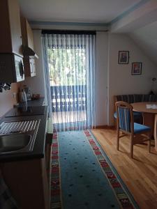 d'une cuisine et d'une salle à manger avec une table et une fenêtre. dans l'établissement Ferienwohnung Haus Gatternig, à Seeboden
