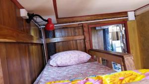 um pequeno quarto com uma cama e um vaso vermelho na parede em Cactus Hostel em Chiang Mai