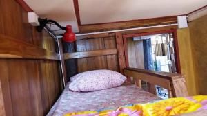 una piccola camera da letto con un letto e un vaso rosso sul muro di Cactus Hostel a Chiang Mai