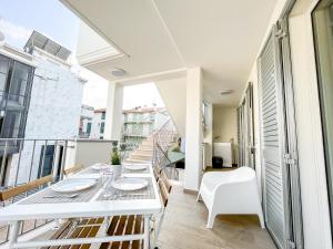 uma varanda com uma mesa branca e cadeiras em Homiday - Residenza Caravelle em Pineto