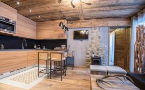 a kitchen with a bar and a fireplace at Les Grands Montets Hotel & Spa in Chamonix