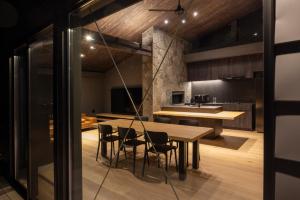 a kitchen and dining room with a wooden table and chairs at Hakuba Aurora Chalet by Jade Villa in Hakuba
