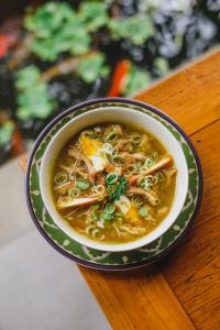 a bowl of noodle soup on a wooden table at Moson Villa Legian in Seminyak