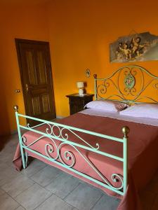 1 cama en un dormitorio con pared de color naranja en B&B Casa Vigne, en Castrovillari