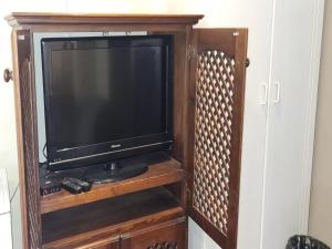 un centro de entretenimiento de madera con TV en Alexandra Bed & Breakfast, en Pelham