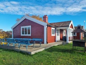 una casa con bancos azules en una terraza de madera en Talluddens Stugby, en Färjestaden