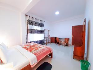 een slaapkamer met een bed en een tafel en stoelen bij Heaven Hills Guest House in Maskeliya