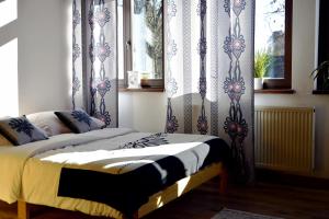 a bedroom with a bed with blue and white curtains at Czarna Willa in Zakopane