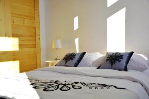 a bedroom with a bed with white sheets and blue pillows at Czarna Willa in Zakopane