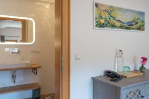 een badkamer met een wastafel, een spiegel en een telefoon bij Hotel Ziegleder in Rottach-Egern
