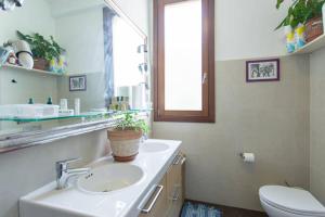 łazienka z toaletą i umywalką z doniczką w obiekcie Mari & Popi’s House w Mestre