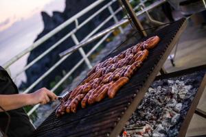 a bunch of sausages cooking on a grill at Blue Bay Resort in Capo Vaticano