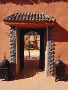 uma entrada para um edifício com um arco e um telhado em Gite d'étape nomade em Tajda