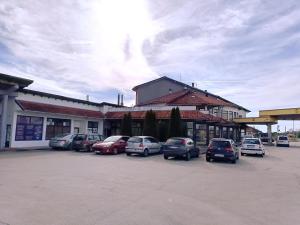 un estacionamiento con autos estacionados frente a un edificio en Motel Gas-Petrol Samac, en Bosanski Šamac