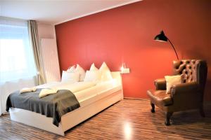 ein rotes Schlafzimmer mit einem Bett und einem Stuhl in der Unterkunft Studio-Apartment Augarten in Wien