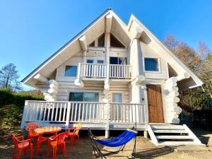 una casa pequeña con porche, mesa y sillas en Polar Haus Canadian NishiKaruisawa1 - Vacation STAY 07669v en Oiwake