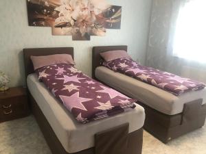 twee bedden in een kamer met paarse en roze dekens bij Berta in Neunkirchen