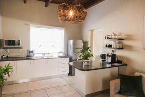 een keuken met een wastafel en een koelkast bij The Olive Tree in Ceres