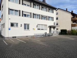 a large white building with a parking lot at Hotel Zum Ritter in Seligenstadt