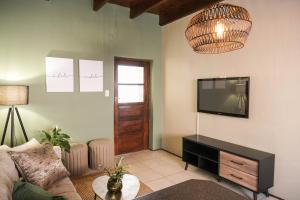 een woonkamer met een flatscreen-tv aan de muur bij The Olive Tree in Ceres