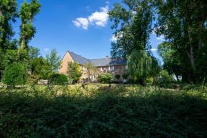 une maison au milieu d'un champ arboré dans l'établissement Au Chantecler, 