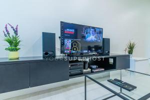 een zwart entertainmentcentrum met een flatscreen-tv bij Family-Friendly 2Bedroom 6Pax Suite Georgetown Netflix WashDryer Machine in George Town