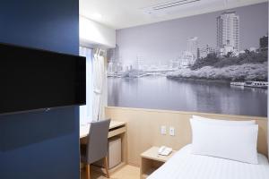 a hotel room with a bed and a view of a river at Travelodge Honmachi Osaka in Osaka