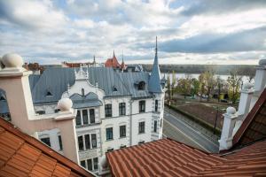 a white building with a blue roof on top of buildings at Loft 38 z tarasem in Toruń