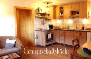 a kitchen with wooden cabinets and a stove top oven at stay & relax am Bio Archehof Zachhiesen in Seekirchen am Wallersee