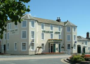 un grande edificio bianco sul lato di una strada di Graham Arms Inn a Longtown