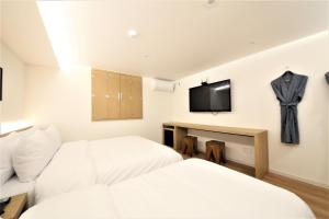 Cette chambre dispose de 2 lits et d'une télévision murale. dans l'établissement 25hours Hotel, à Busan