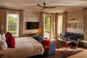 a bedroom with a large bed and a living room at Leeu House in Franschhoek
