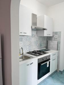 una cucina bianca con lavandino e piano cottura di Residence Terme Belliazzi- Isola d'Ischia a Ischia
