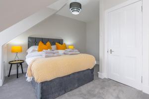a bedroom with a large bed with orange pillows at Luxury 3 Bed Apartment in Aberdeen City Centre. in Aberdeen