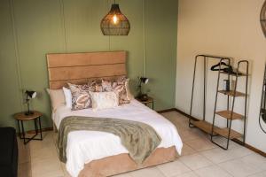 een slaapkamer met een groot bed met kussens erop bij The Olive Tree in Ceres
