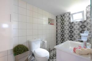 a white bathroom with a toilet and a sink at Santa Barbara lux studio in Marathonas in Lófos