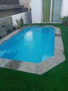a blue swimming pool in a yard with green grass at Riverwalk Villa 