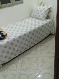 a bed sitting in a room with a floor at غرفة فردية خاصة للاناث in Bel Aroussi