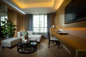 a living room with a couch and a table in a room at Holiday Wuyang Hotel in Hangzhou