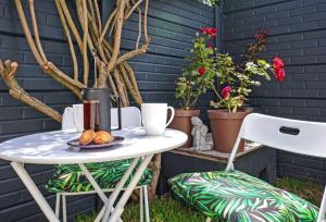 a table and two chairs with a drink on a patio at Flatlet 2.1km from Iconic Blaauwberg Beach in Cape Town