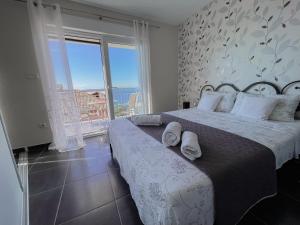 a bedroom with a large bed and a large window at Ferienhaus Ivanka in Trogir