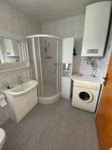 a bathroom with a shower sink and a washing machine at Troadkastn Familie Fritz in Passail
