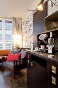 a kitchen with a living room with a couch at Henri Hotel Hamburg Downtown in Hamburg