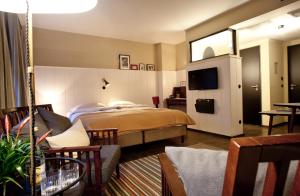 a hotel room with a bed and a tv at Henri Hotel Hamburg Downtown in Hamburg