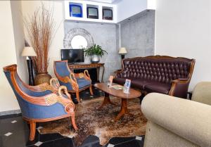 - un salon avec un canapé, des chaises et une table dans l'établissement Residencial Colombo, à Funchal