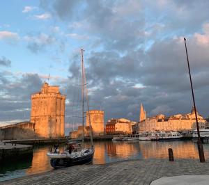 un barco en el agua frente a una ciudad en Nuits océanes à La Rochelle avec parking privatif, en La Rochelle