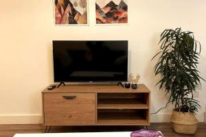 En TV eller et underholdningssystem på Cosy 1 bedroom apartment with car park space.