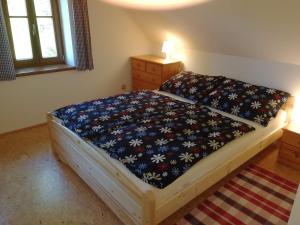 sypialnia z łóżkiem z narzutą kwiatową w obiekcie Chalupa Rejvíz w mieście Rejvíz
