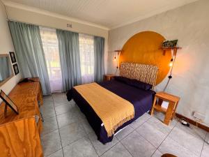 a bedroom with a large bed in a room at Firefly Budget Friendly Guest House in Kempton Park